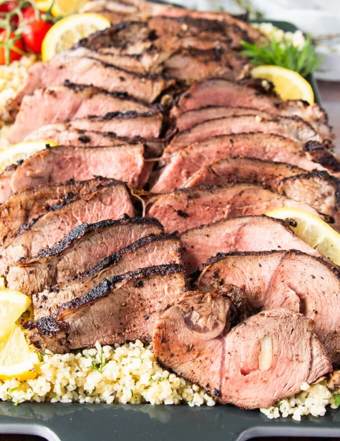 sliced butterflied leg of lamb arranged on a plate