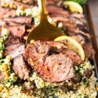 close up of a serving of butterflied leg of lamb on a slotted spoon showing the texture close up