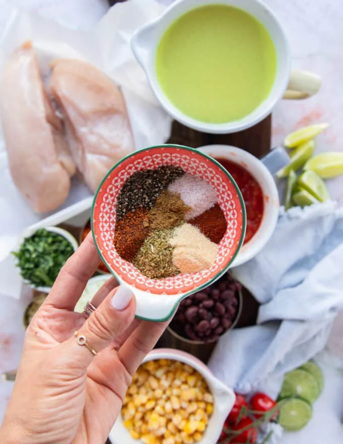A hand holding a bowl of taco seasonings homemade ready to blend