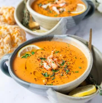 close up bowl of crab bisque with crab lumps on top and parsley