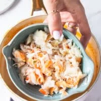 crab meat in a bowl being added to the soup pot