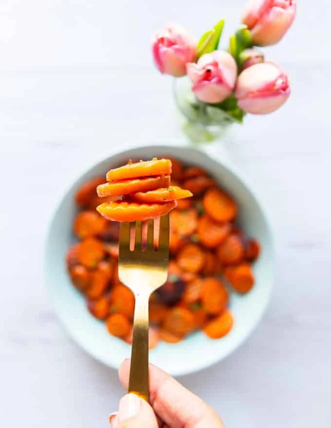 Fork showing a serving of golden maple glazed carrots perfectly cooked