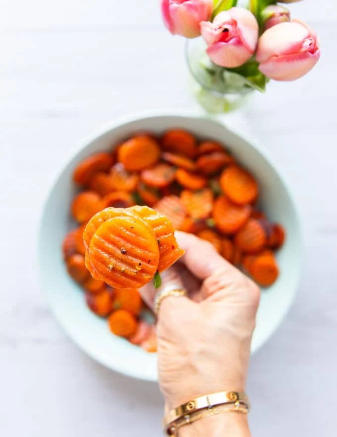 close up of a fork showing the maple glazed carrots golden color and soft texture