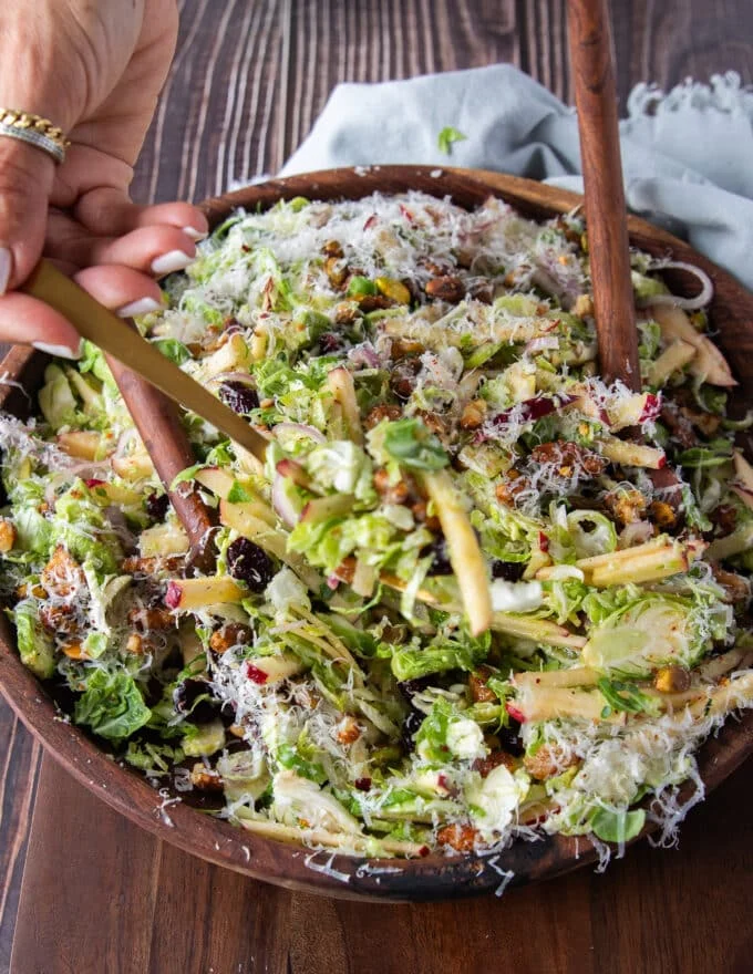 A full serving of brussel spout salad with candied walnuts, apples, cranberries and lots of parmesan cheese
