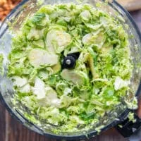 fully shredded brussel sprouts in the bowl of a food processor