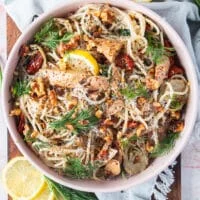 top view of a bowl of tuna pasta with fresh dill and lemon slices