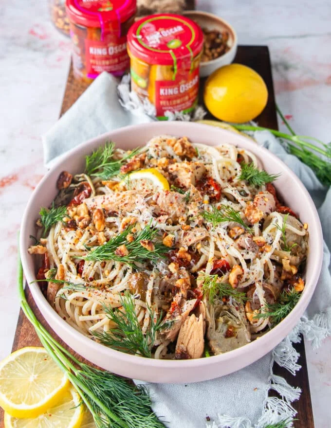 Flakey tuna pasta bowl with herbs, lemon and some lemon zest on top