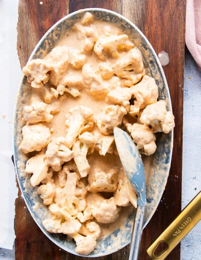 the cauliflower is tossed in the batter and coated evenly with the thick batter