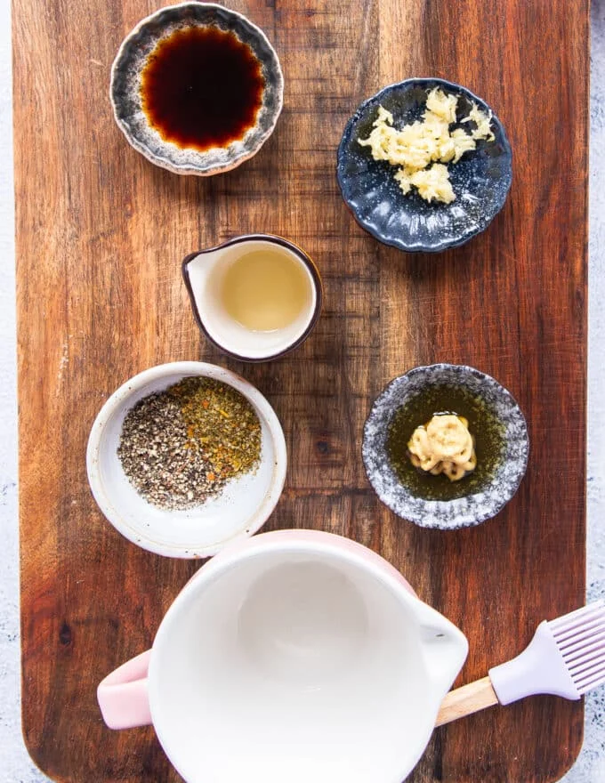 small bowls of marinade for the kingfish steaks including minced garlic, mustard, honey ,soy sauce, herbs, olive oil and more