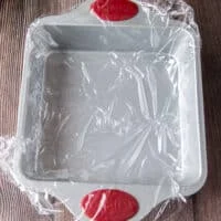 lined square pan with plastic wrap ready for the rice to go on top