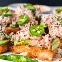 close up of one spicy tuna crispy rice showing the crisp golden brown and the creamy tuna topping