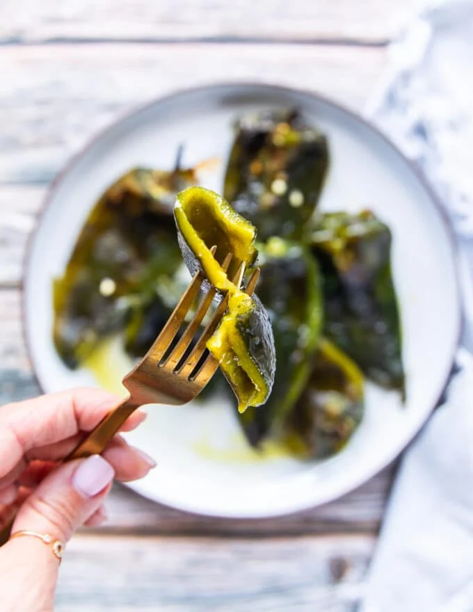 A fork holding a piece of roasted poblano peppers close up showing the soft texture