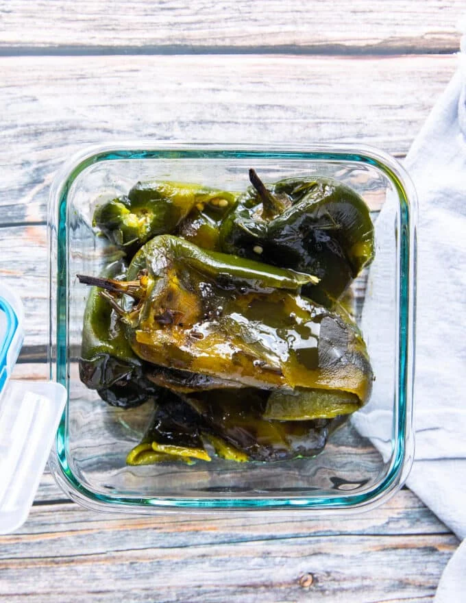 roasted poblano peppers in an airtight container stored for later in olive oil