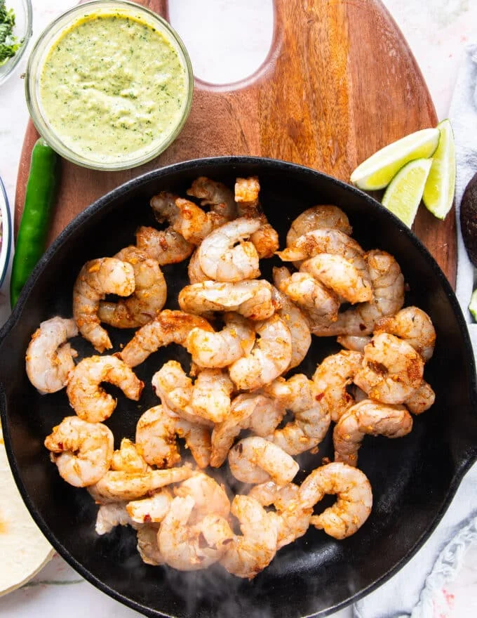 seasoned shrimp added to a skillet to cook