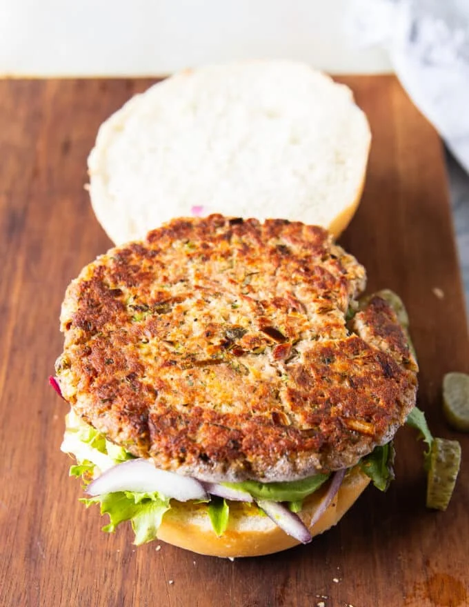 The tuna patty recipe is added over the toppings on the bun