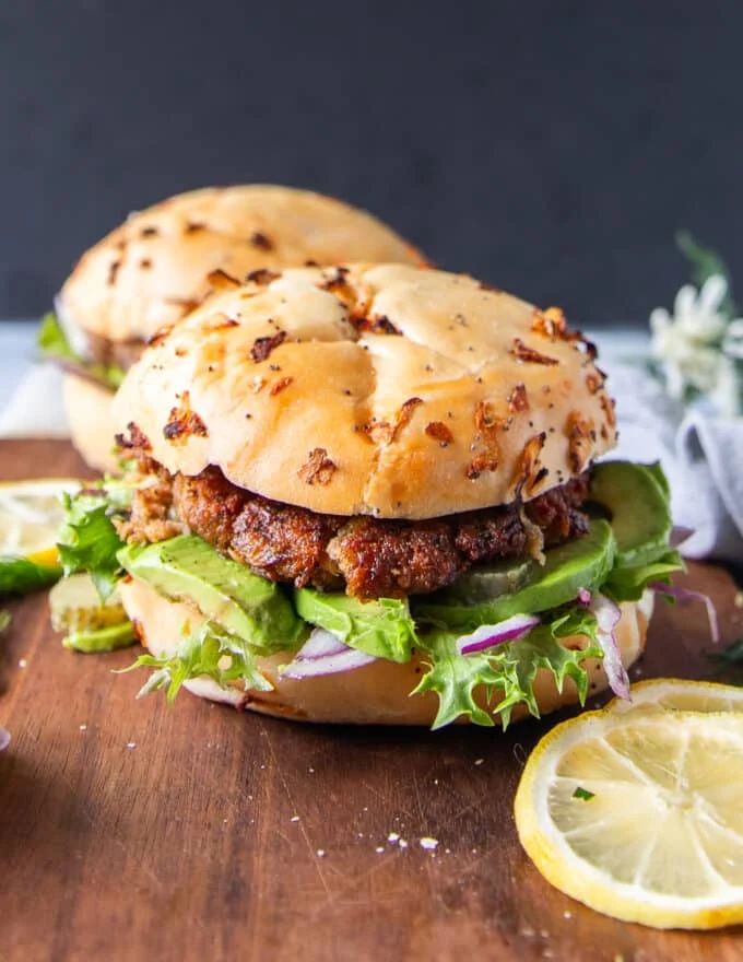 Close up pf a tuna burger showing the tuna burger patty recipe and bun along with the toppings