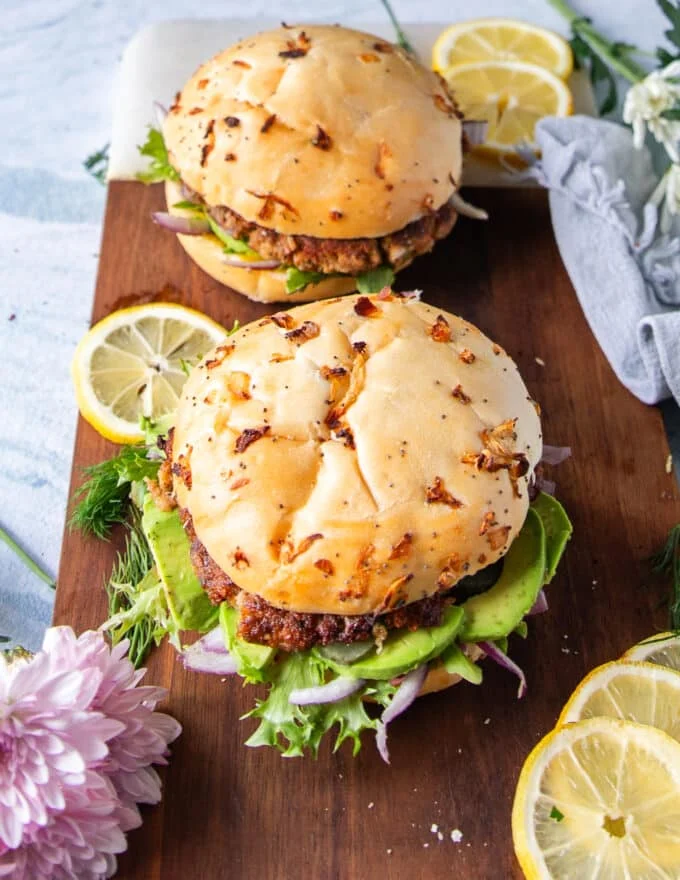 The tuna burgers assembled and ready on a board ready to serve