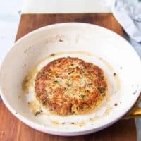 Tuna patty flipped in a skillet to show the golden tuna burger cooking