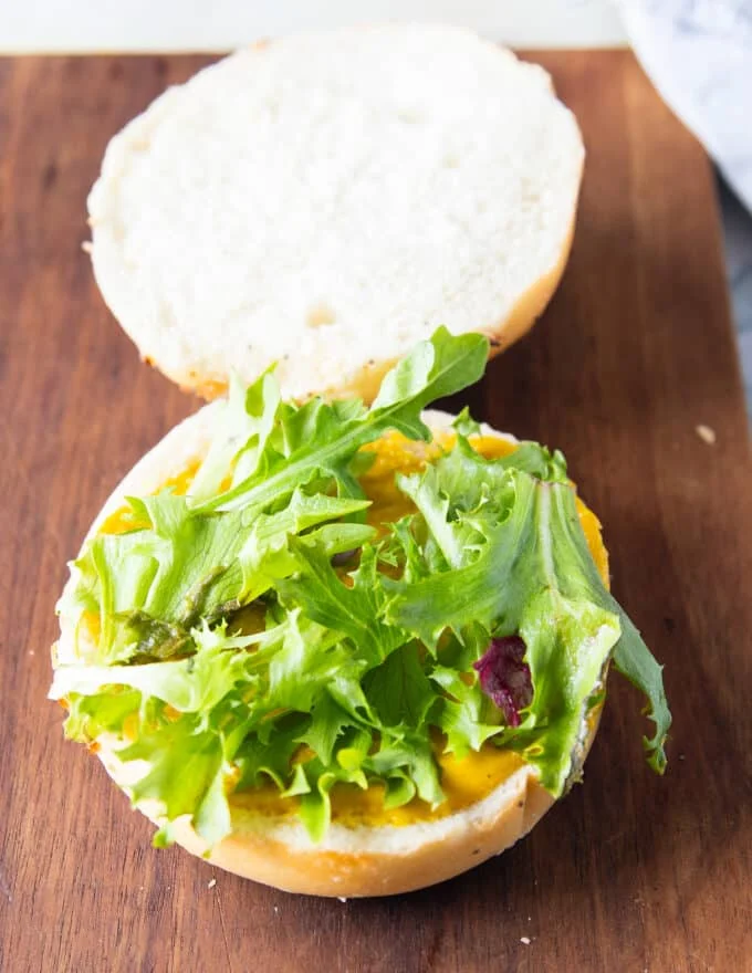 Assembling the tuna burger, a spread of sauce, some lettuce