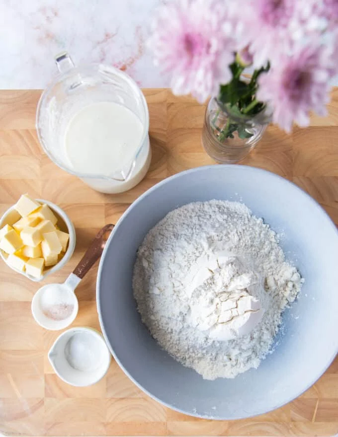 ingredients needed to make air fryer biscuits recipe on a board with small bowls of different ingredients