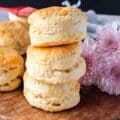 Stacks of air fryer biscuits on a wooden board show how tall and fluffy the biscuits are
