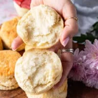 A hand holding an air fryer biscuit cut in half showing the fluffy interior
