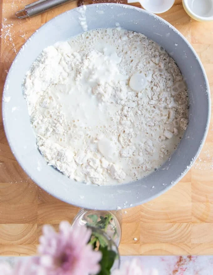 the buttermilk added to the bowl of flour and butter mixture
