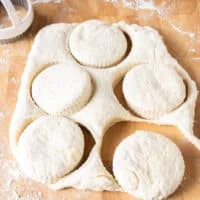 cut up pieces of biscuits from the biscuit dough on a board