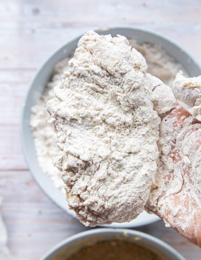 The final thick coating of flour is added to the chicken before frying