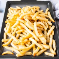 seasoned cooked and crispy fries on a baking sheet seasoned