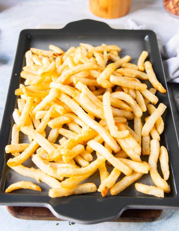seasoned cooked and crispy fries on a baking sheet seasoned