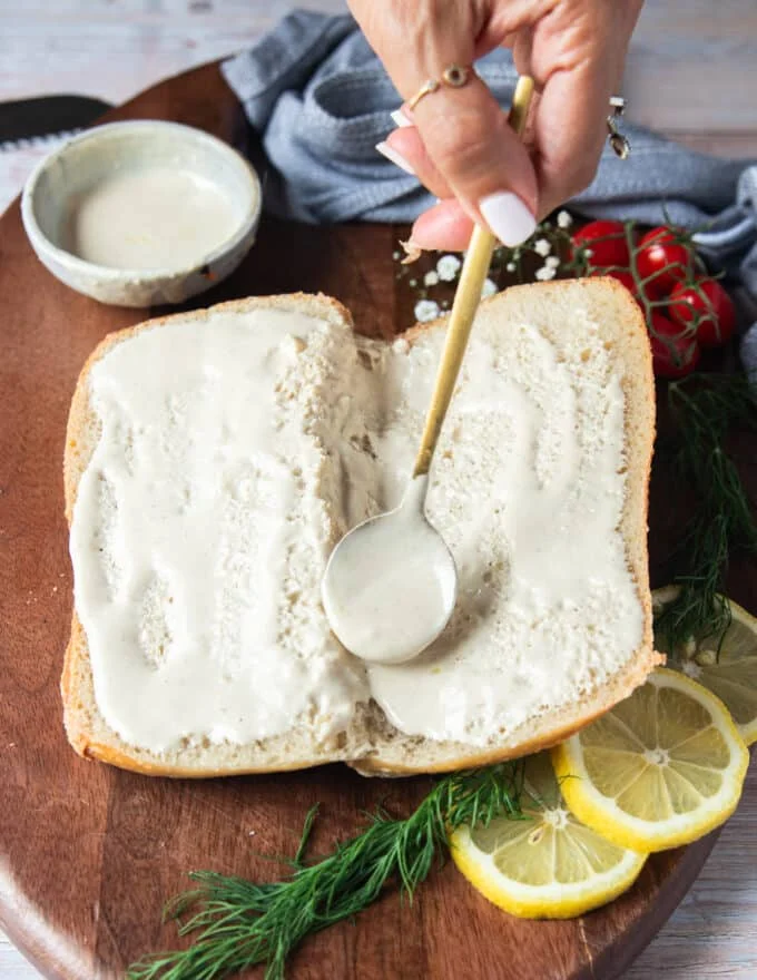 Spread tahini sauce over the crusty bread
