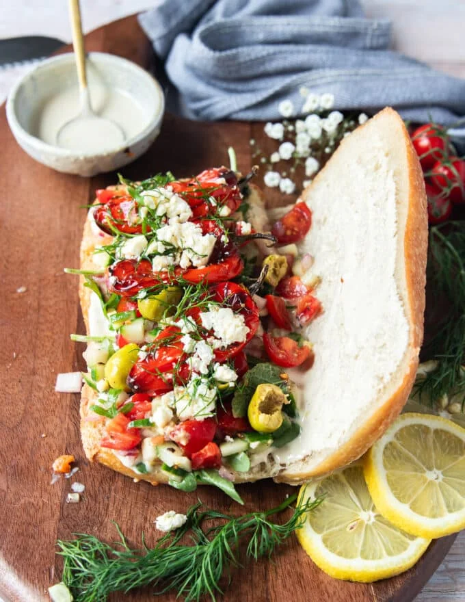 The fresh ingredients are added over the creamy sauce on the bread
