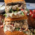 Cut up sardine sandwich in half close up shwoing the layers of sardines and fresh ingredients stuffed inside the sandwich bread