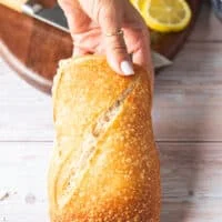 A hand holding a rustic ciabatta bread ready to toast it for maximum crunch on the sandwich