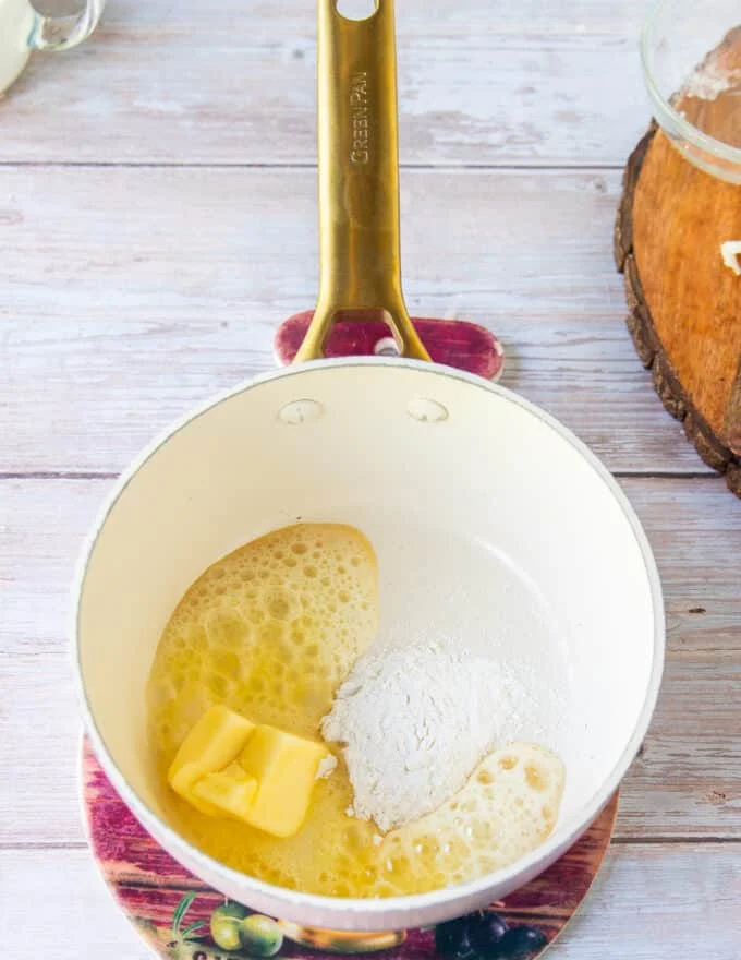 Butter and flour are added to a pan to make the base of the queso