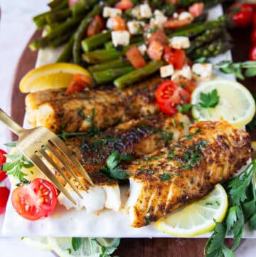 A fork flaking succulent air fryer cod showing how perfectly cooked in the air fryer