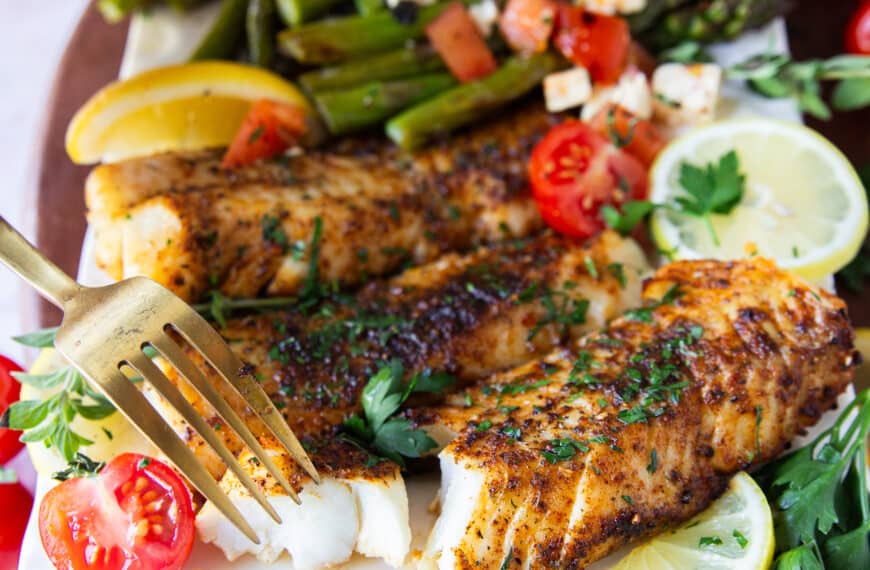 A fork flaking succulent air fryer cod showing how perfectly cooked in the air fryer