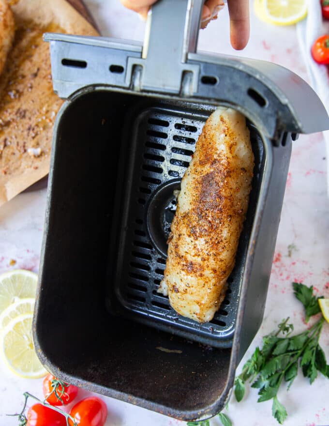 cod arranged in a single layer in an air fryer basket