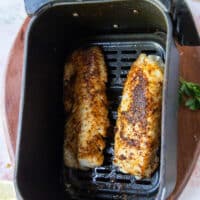 Perfect cooked air fryer cod in the air fryer basket.