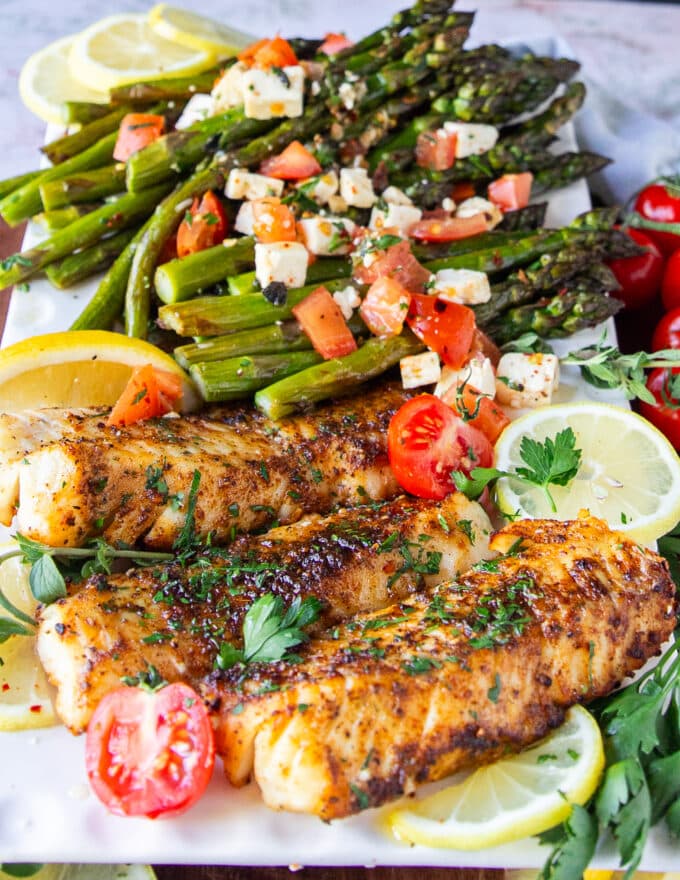 close up of an air fryer fish on a platter showing crisp brown exterior and juicy fish