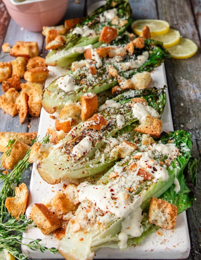 the grilled romaine plate is now topped with cheese, croutons, herbs and some chili flakes