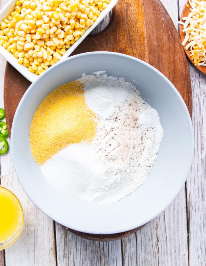 A bowl with the dry ingredients being mixed in to make jalapeno cornbread