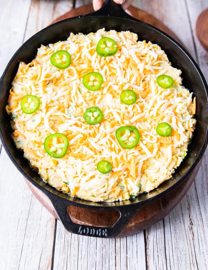 grated cheddar cheese and sliced jalapenos are added over the top of the batter before baking
