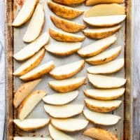 Potatoes washed and cut into wedges, laying on a baking sheet