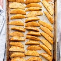 Seasoned potato wedges on a baking sheet in a single layer and ready to bake