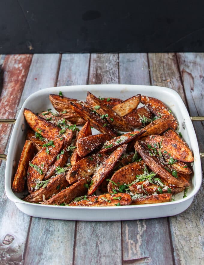 Close up of potato wedges with parmesan and herbs