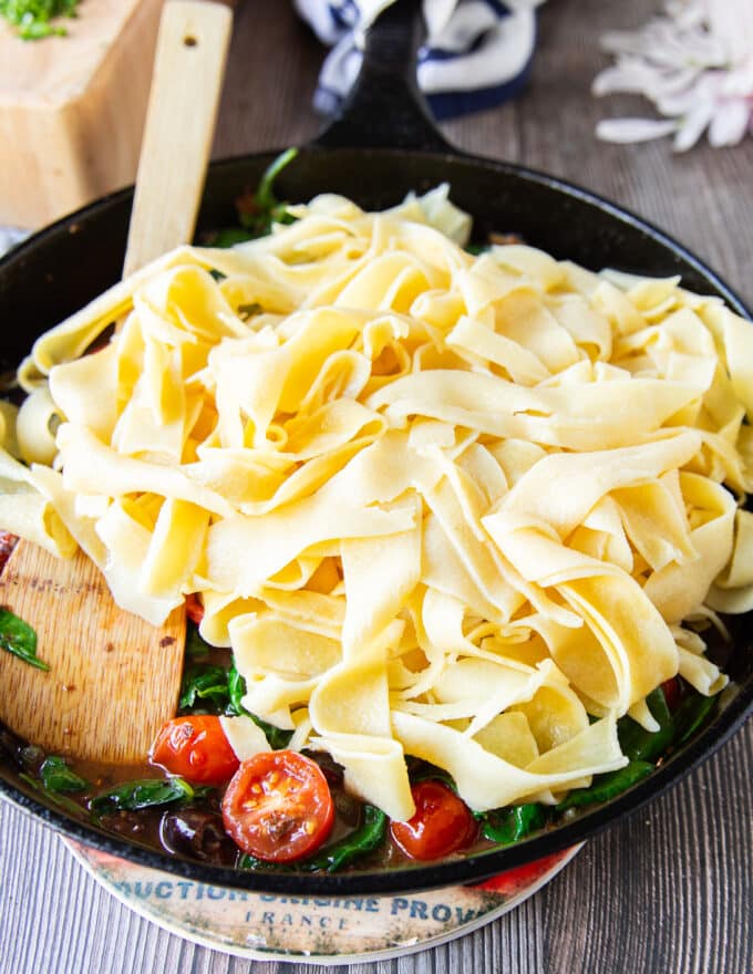 the cooked pasta is added to the sauce in the same pan