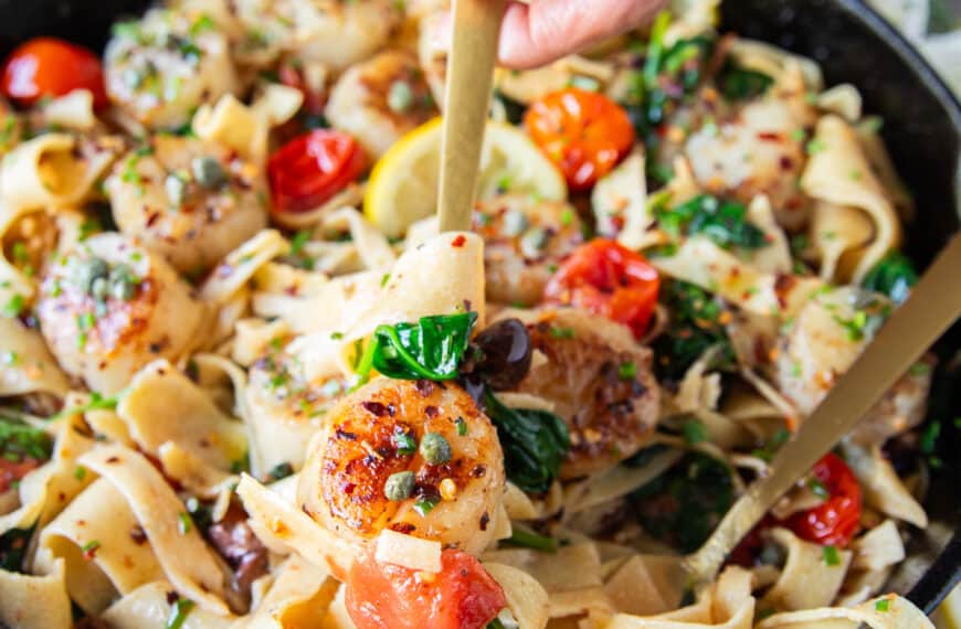 A fork showing scallop pasta close up with the pasta and scallops all cooked to perfection
