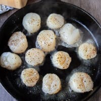 Scallops added to a hot pan for searing in butter